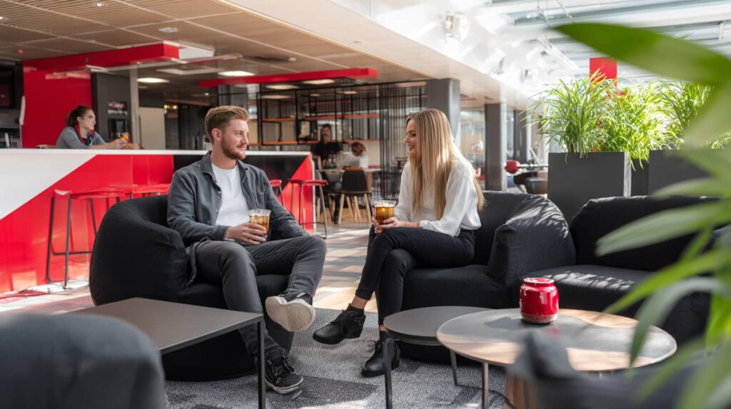 Zwei Personen genießen Cocktails in einem modernen Ambiente mit einer Cocktailmaschine von The Cocktailmaker, ideal für Gastro-Bedarf.